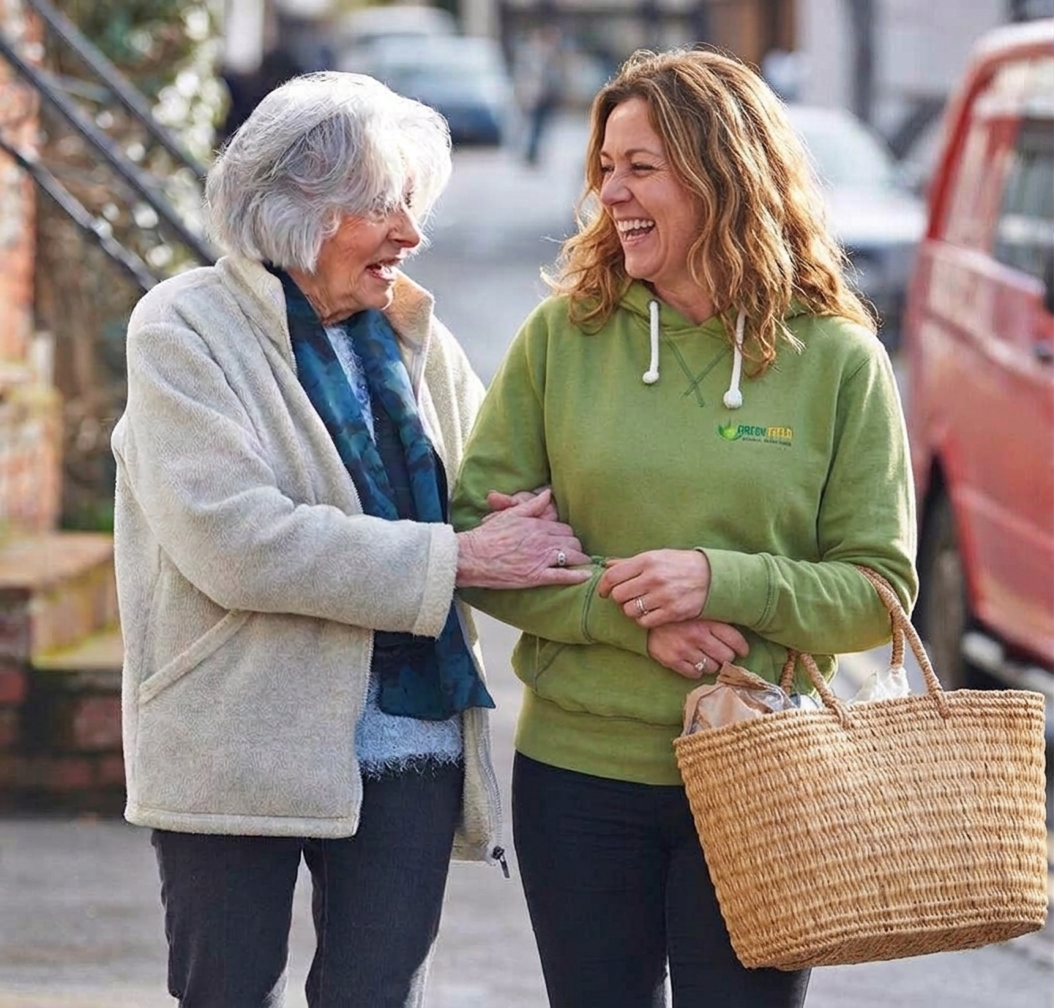 Companion walking arm in arm with elderly client